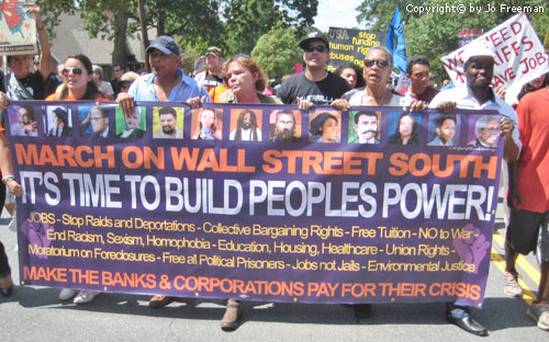 Many people hold a banner reading March on Wall Street South its time to build peoples power
