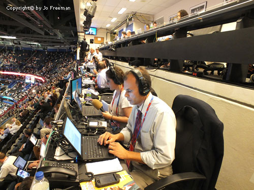 people appear engrossed in working on their laptops in the upper levels of the convention