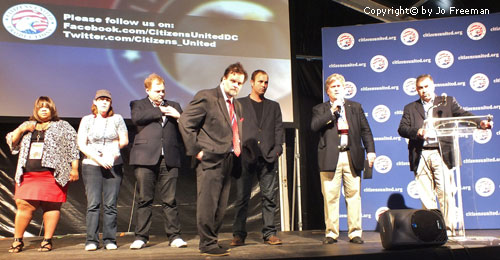 Officers and participants stand on a stage