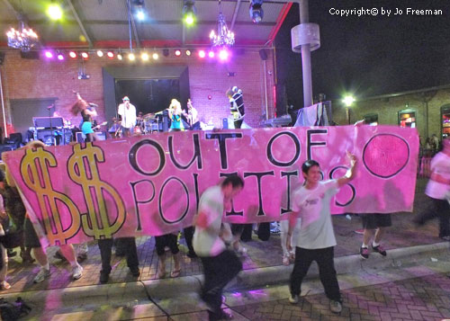Protestors dance in front of a stage