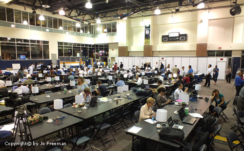 people sit at long tables in a large room