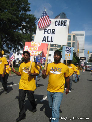 People carry protest signs in a parade