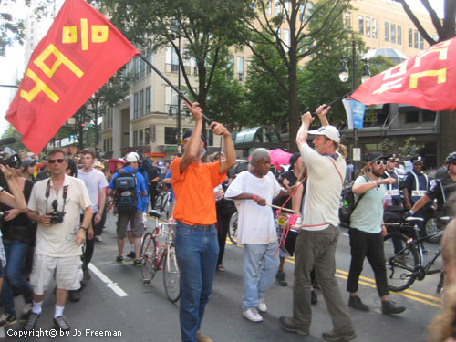 Protestors wave red flags reading 49%