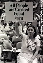An asian-american female deligate holds a sign reading All People Are Created Equal ERA 82