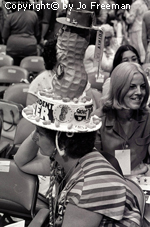 A carter supporter lounges in a hat with a gigantic peanut on top.