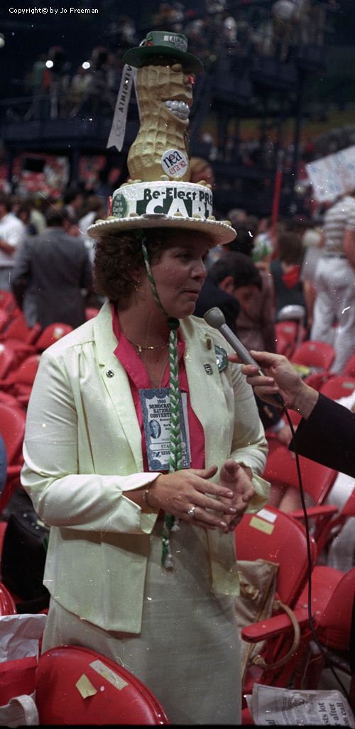 Lady deligate wears a hat with a huge peanut on top.  The hat reads re-elect president Carter.