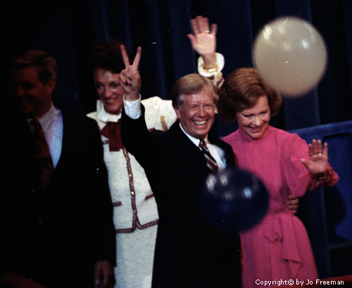 The candidates and their wives wave, Carter holds up a peace sign.