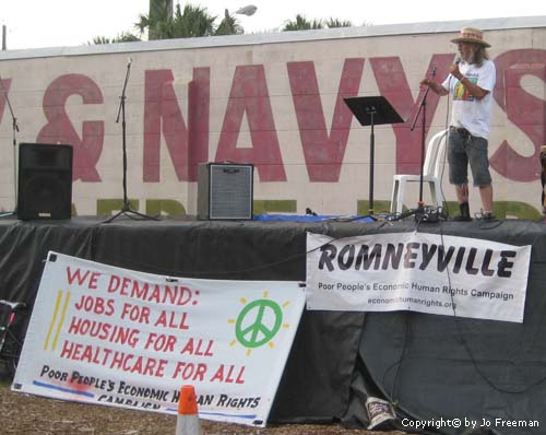 a stage in front of the army navy surplus store with Romneyville signs in front