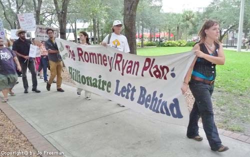 Protestors carry a sign reading No Billionaire Left Behind