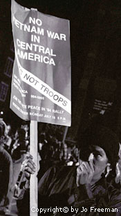 a man holds a sign reading no vietnam war in central america