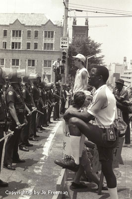 a line of protestors face a line of police