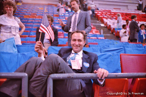 Congressman Schumer reclines and waves a flag