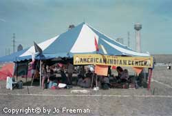 a large sign on a tent reads American Indian Center.